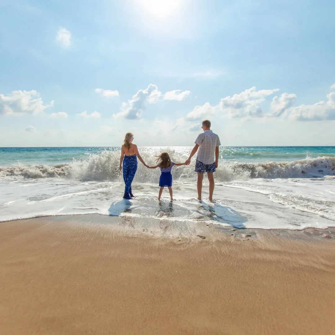 family of three enjoying the beach
