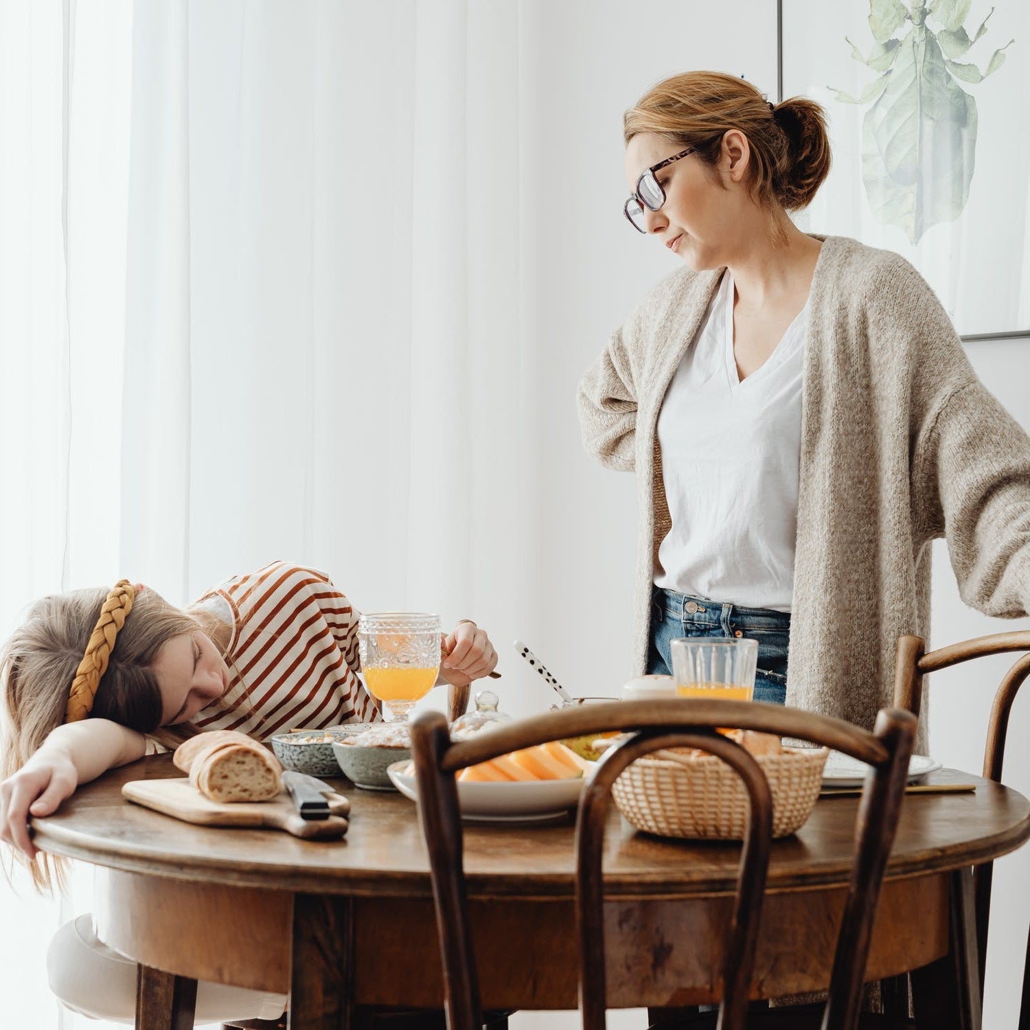 mom talking to teenage daughter on the table