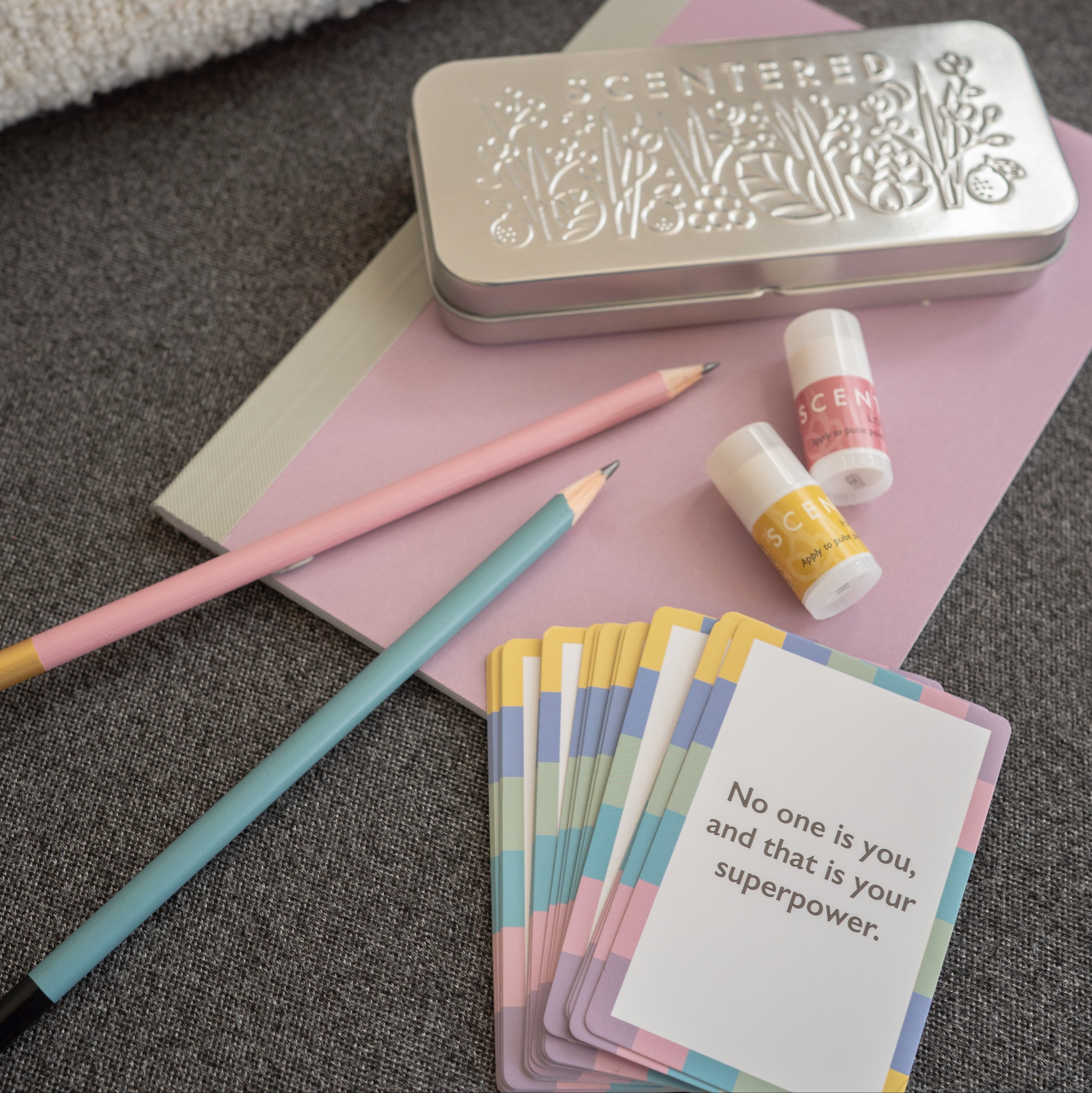 There are pencils, two mini balms ,a tin and cards on the book.
