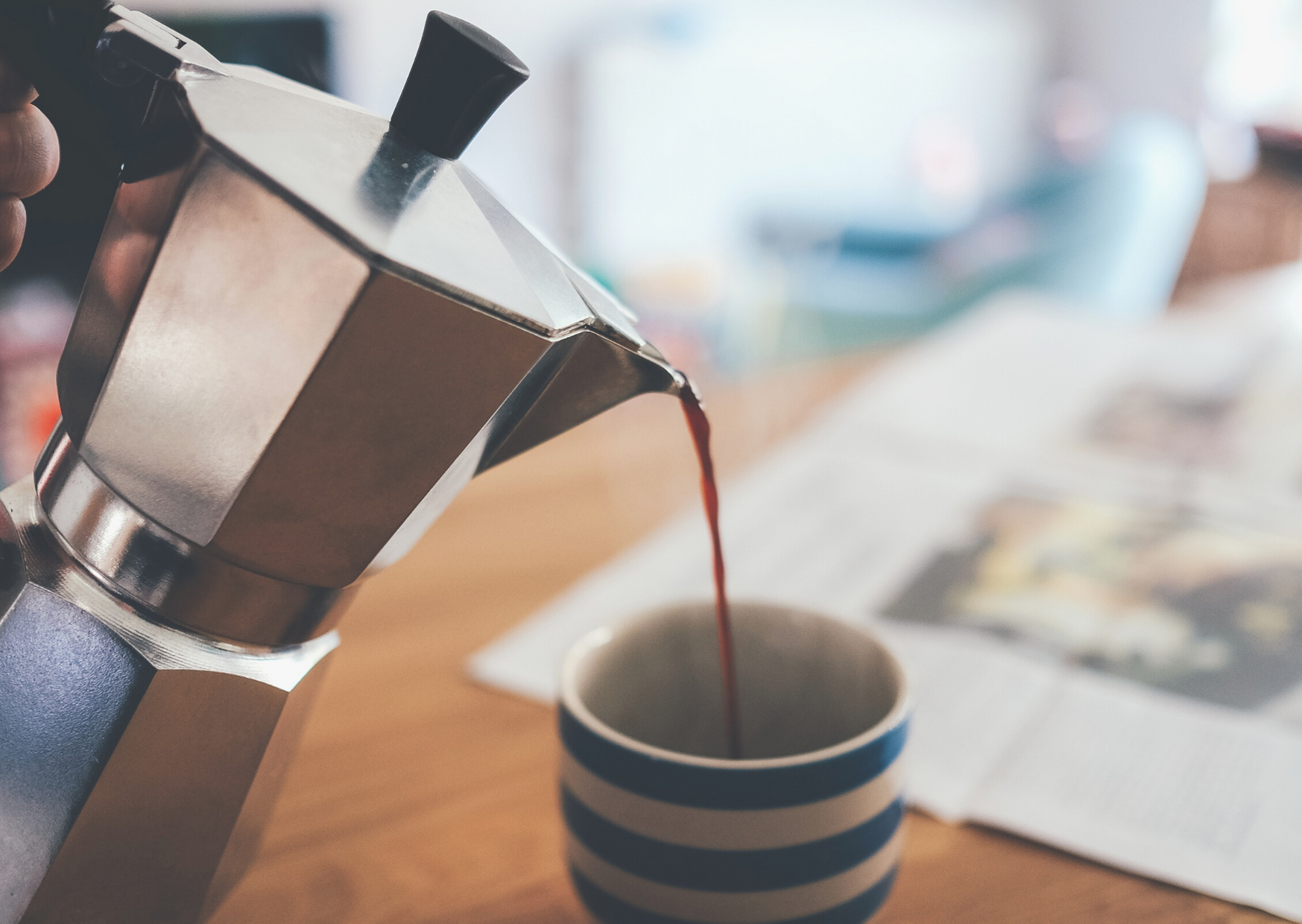 Italian coffee maker pouring on a cup