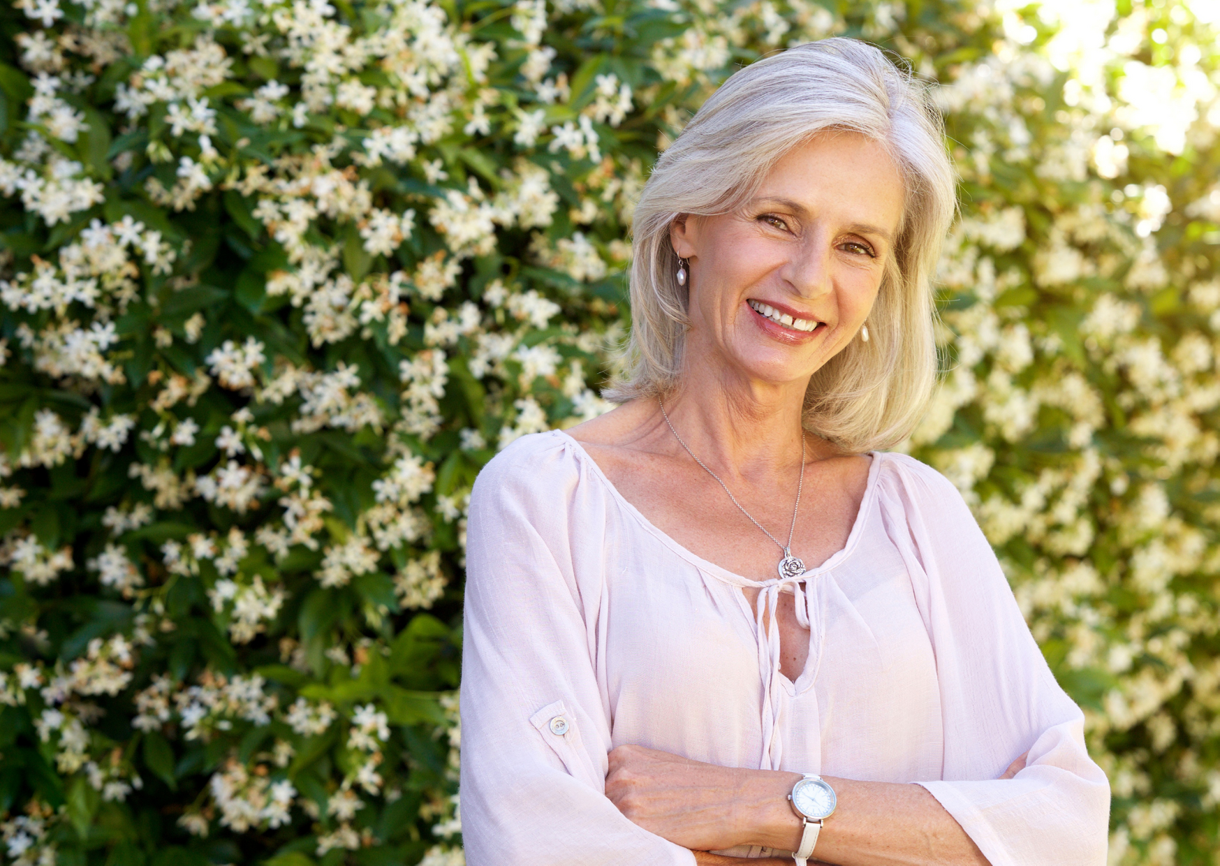 woman smiling in a background of flowers