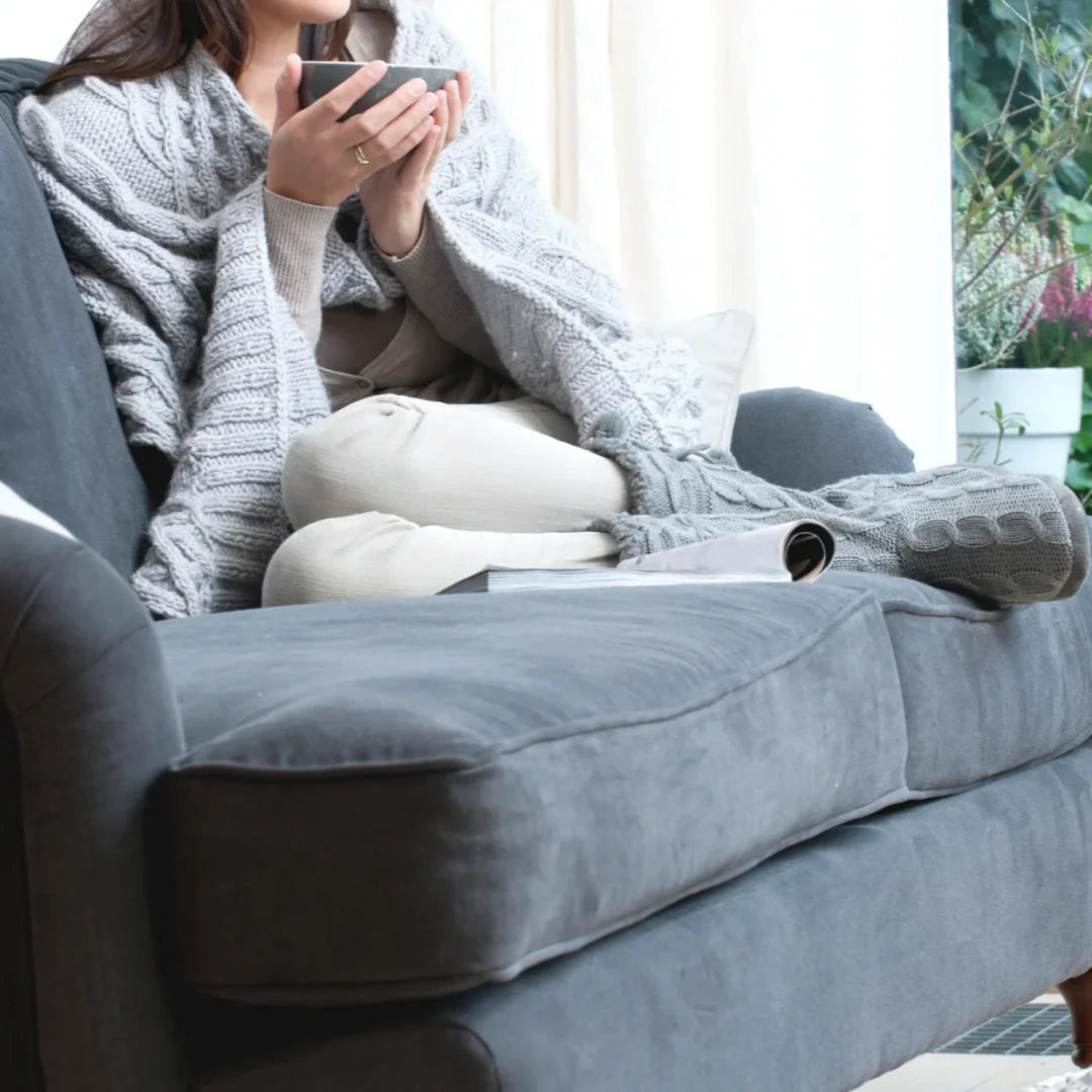 woman having tea in a cozy sofa