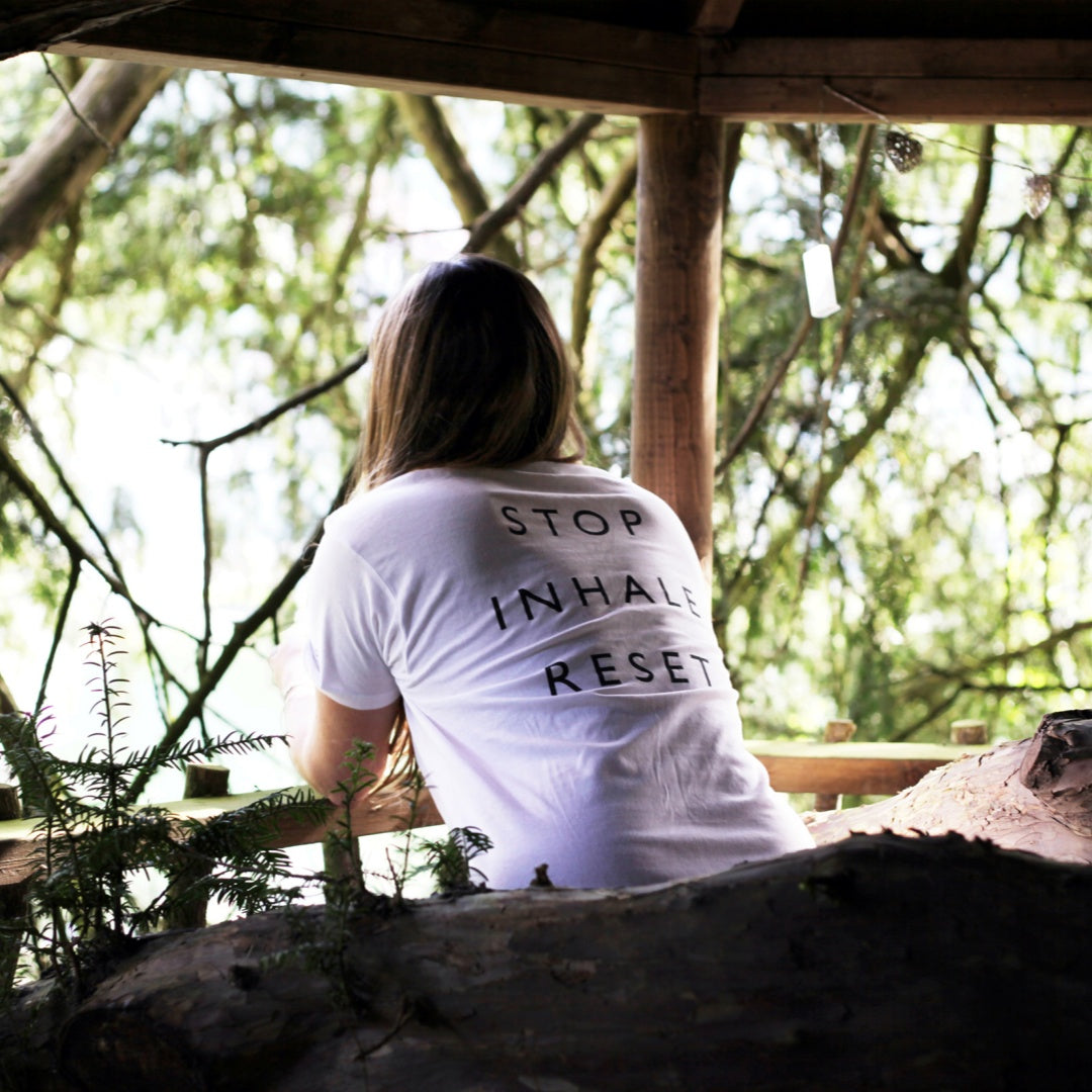 A woman sitting by the window, smelling the nature
