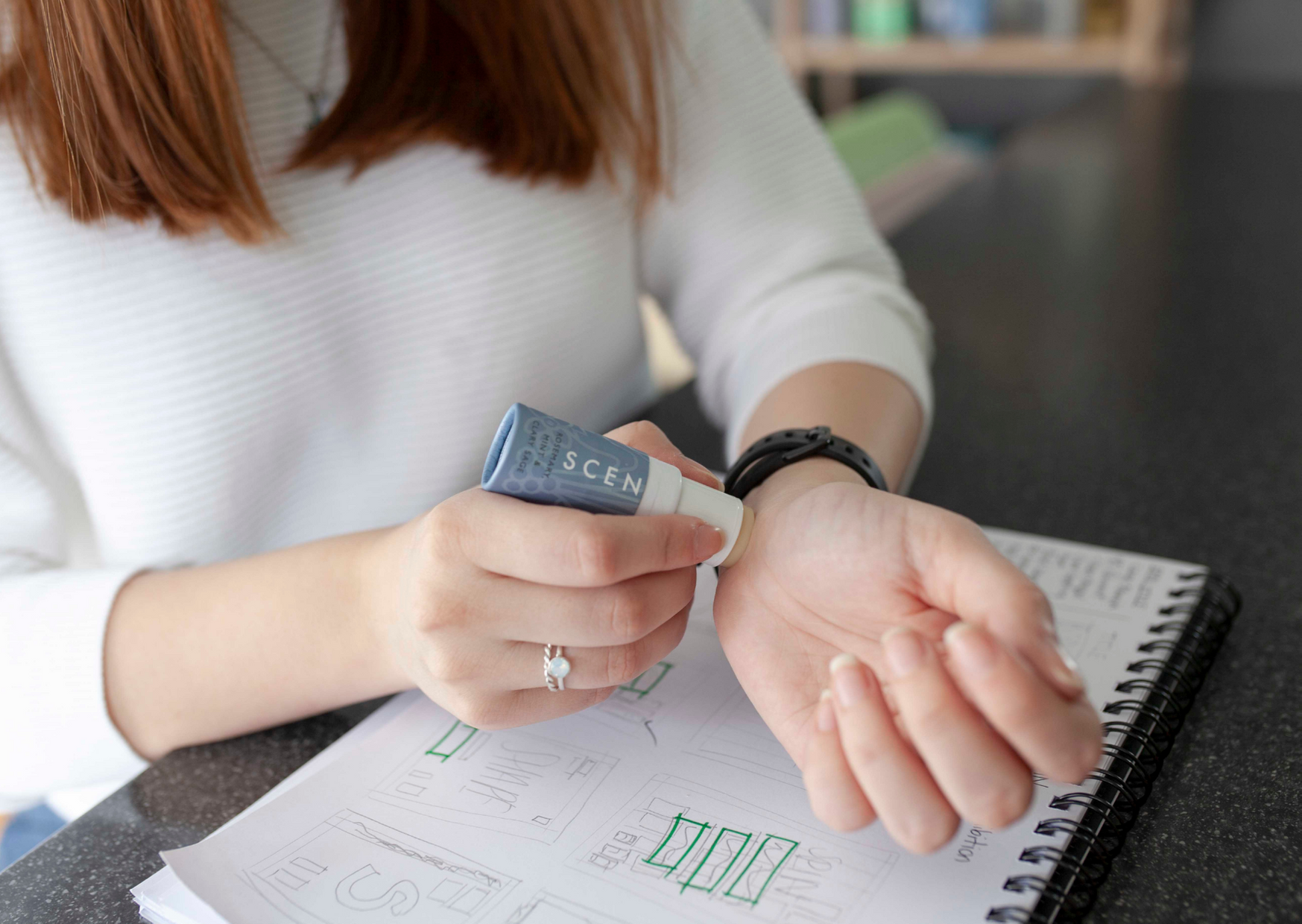 woman applying balm in her wrist at work