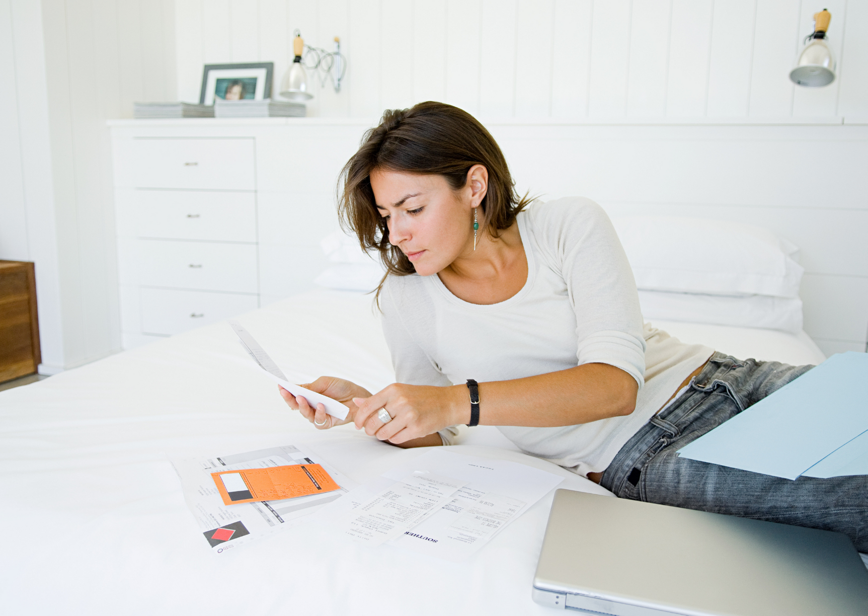 woman checking documents in bed