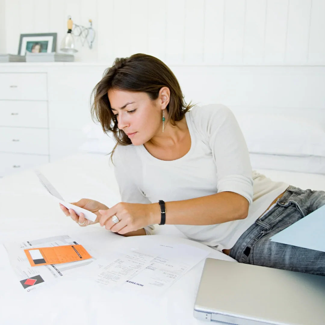 woman checking documents in bed