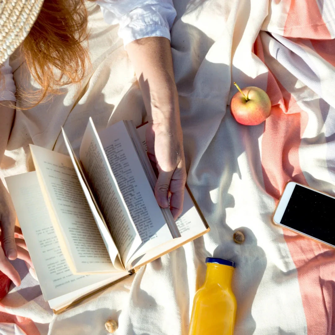 woman reading in a picnic blanket 