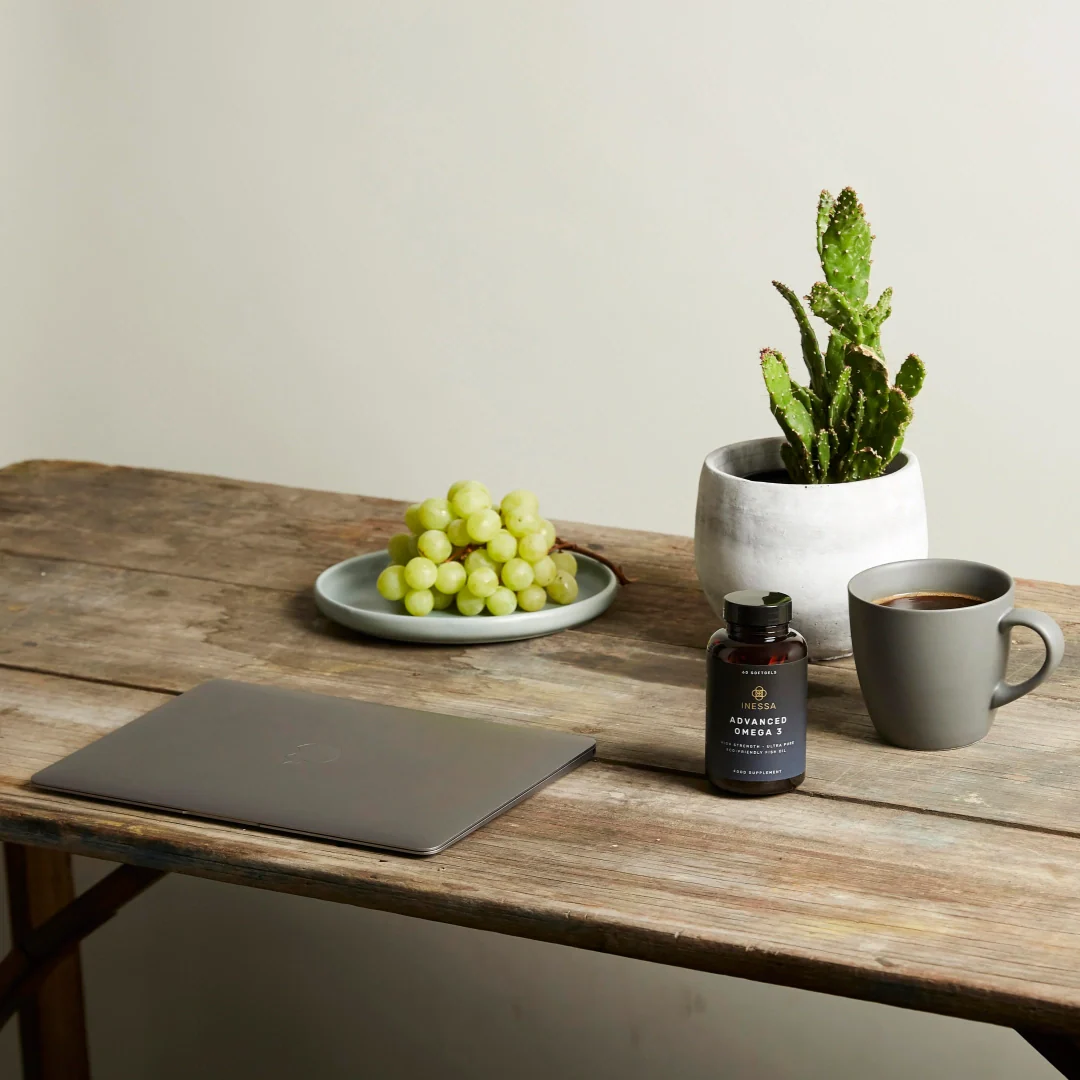 laptop, coffee, grapes and plant on desk