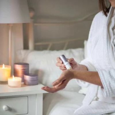 woman applying aromatherapy balm in bed