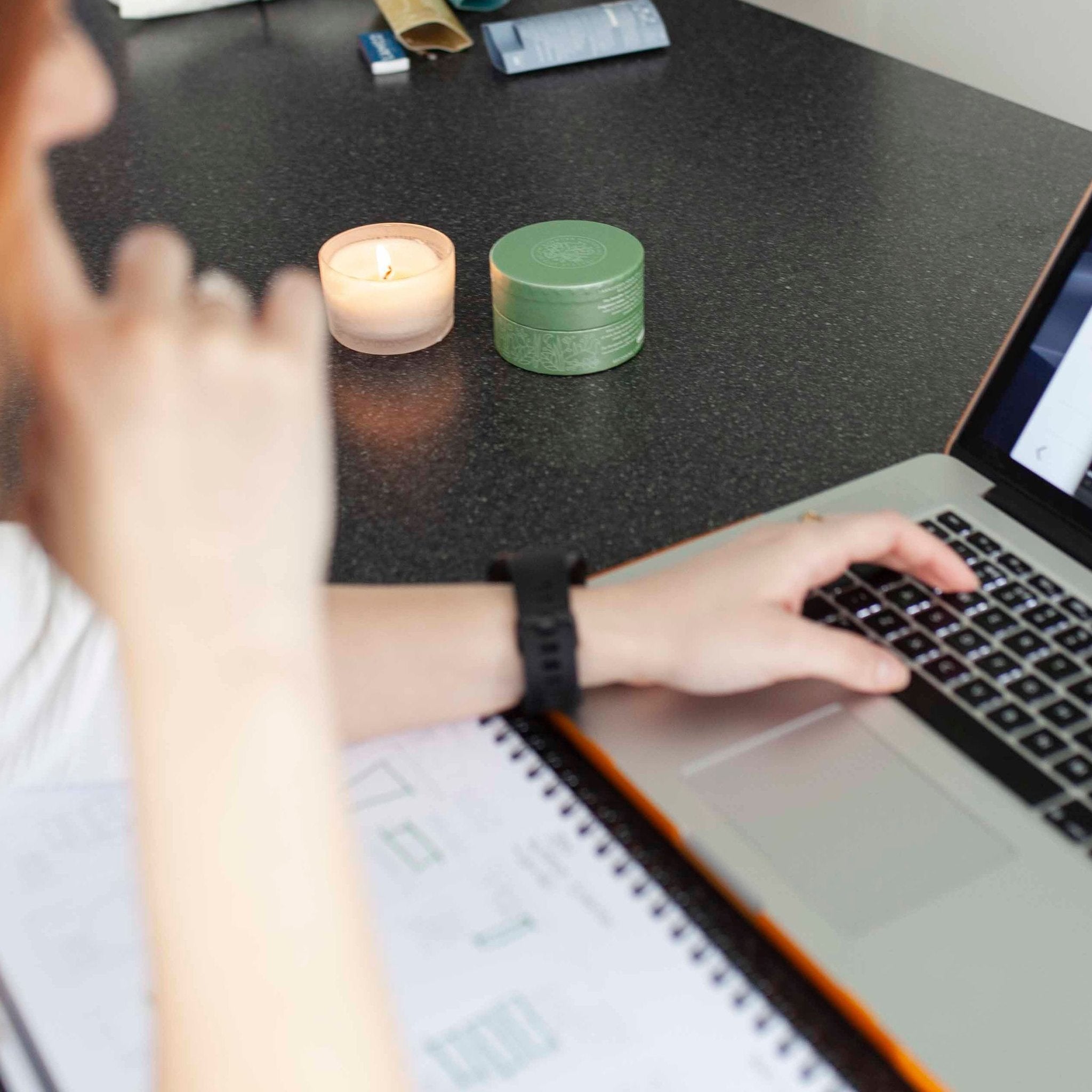 woman working next to a lit candle