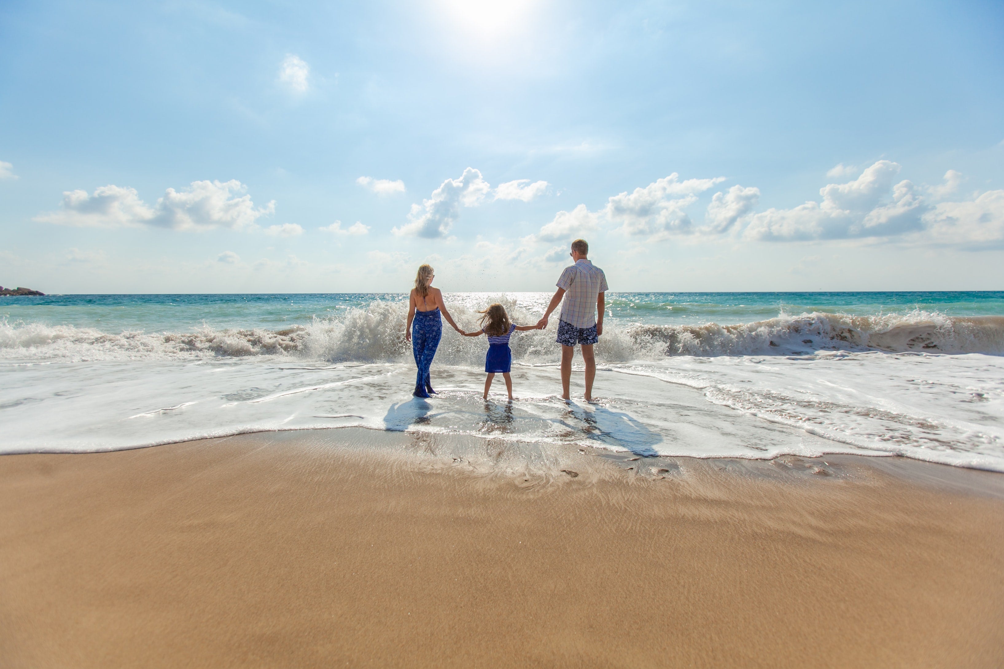 family of three enjoying the beach
