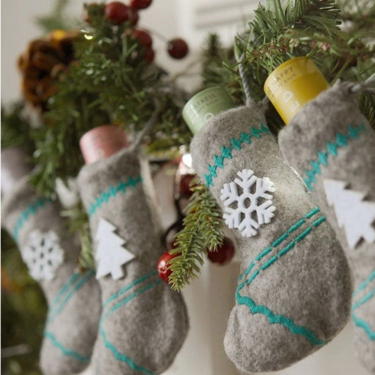 Scentered Aromatherapy Balm stocking set, 4 stockings with balm, each one hanging from a mantle piece garland 