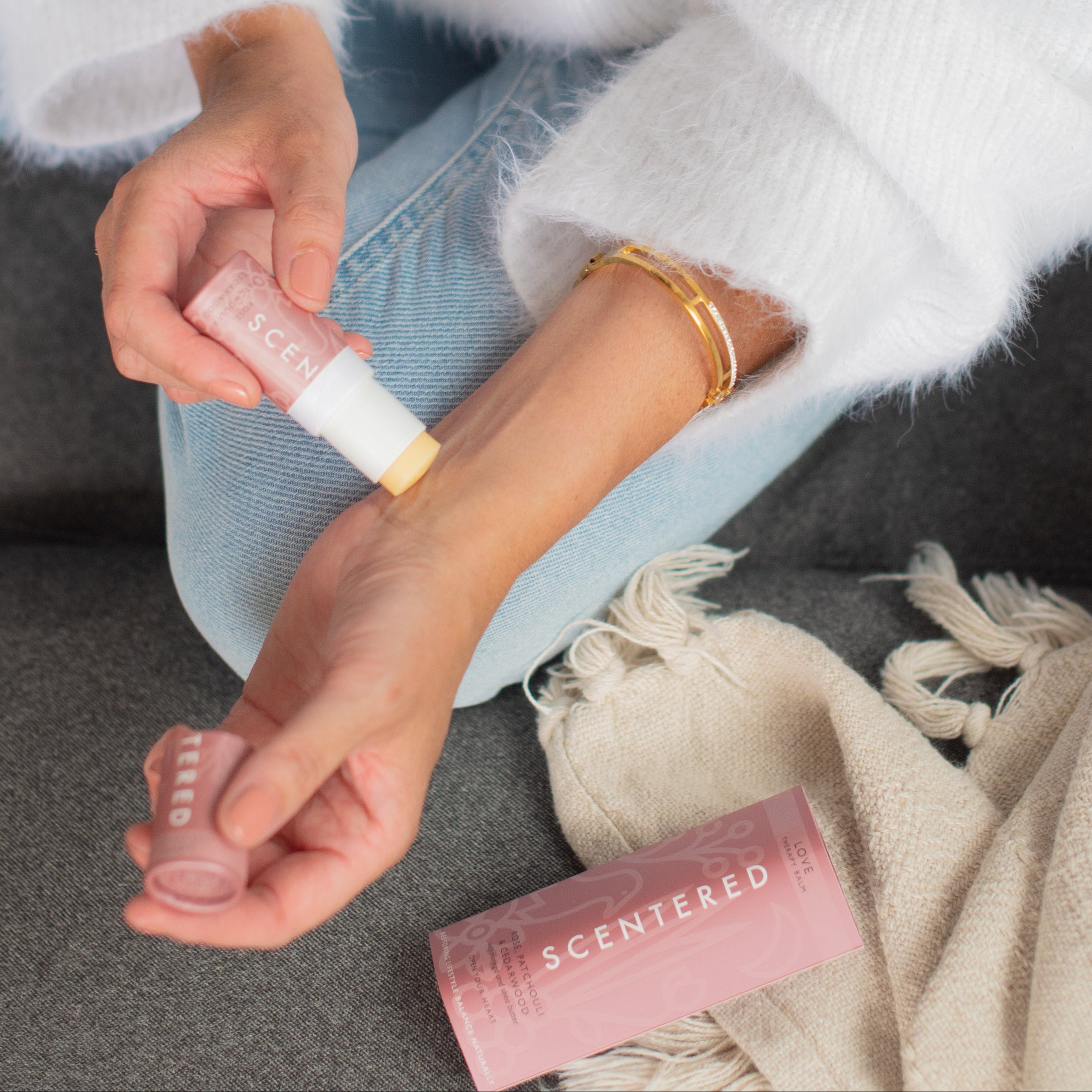 Person holdi a love balm and apply on her wrist