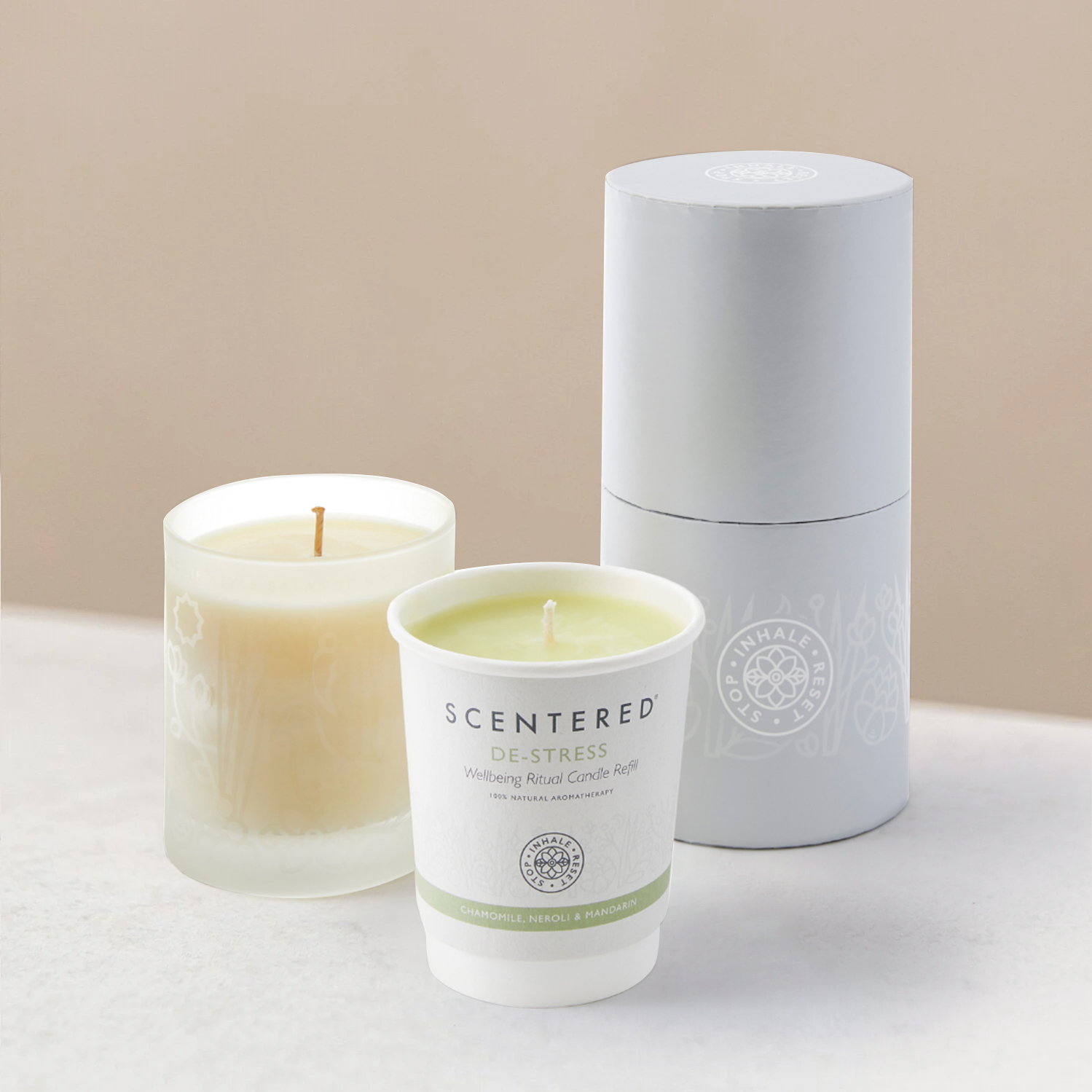 Two de-stress candles, one in a glass container and one in paper cup.
