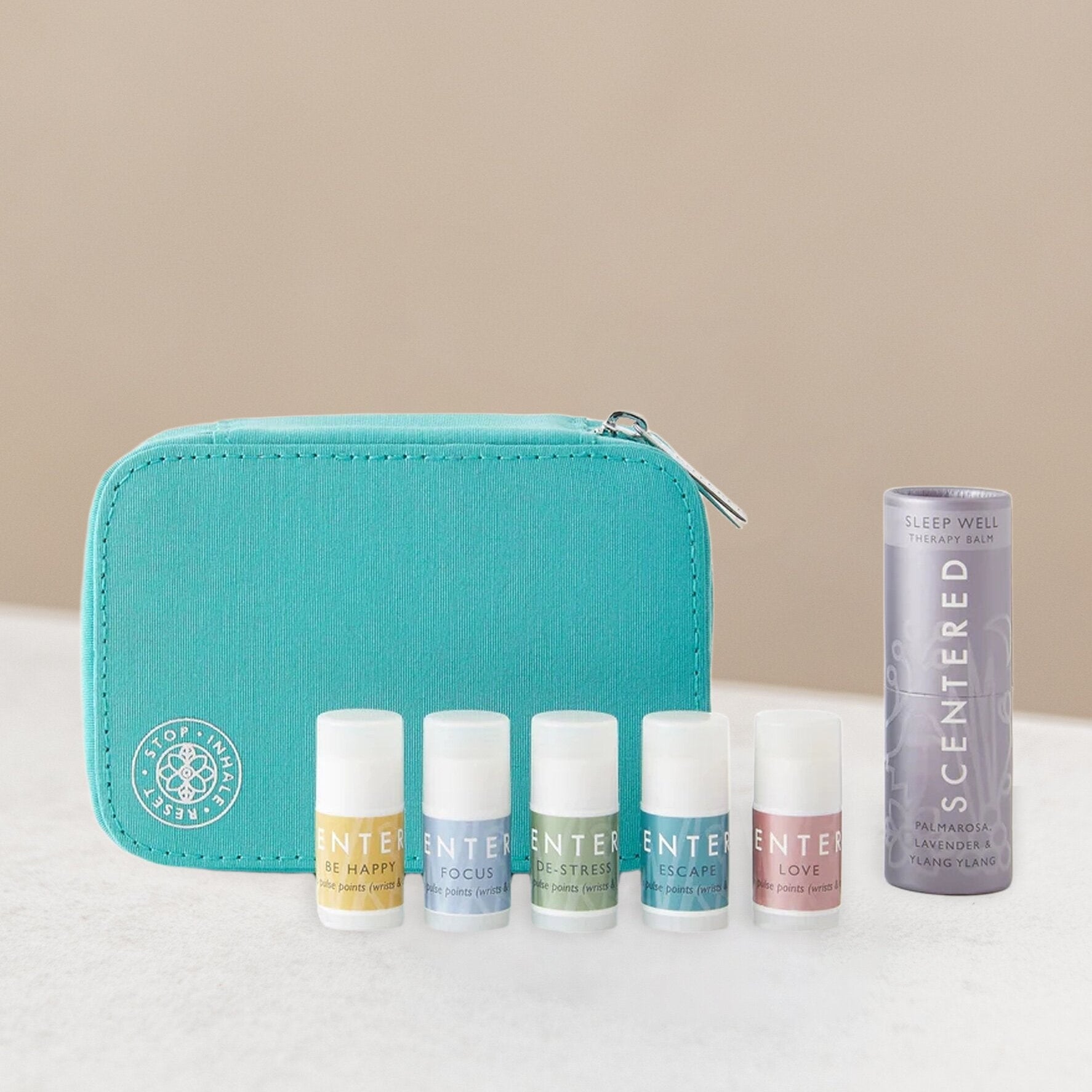 Set of mini balms and sleep balm with a teal pouch on a light background