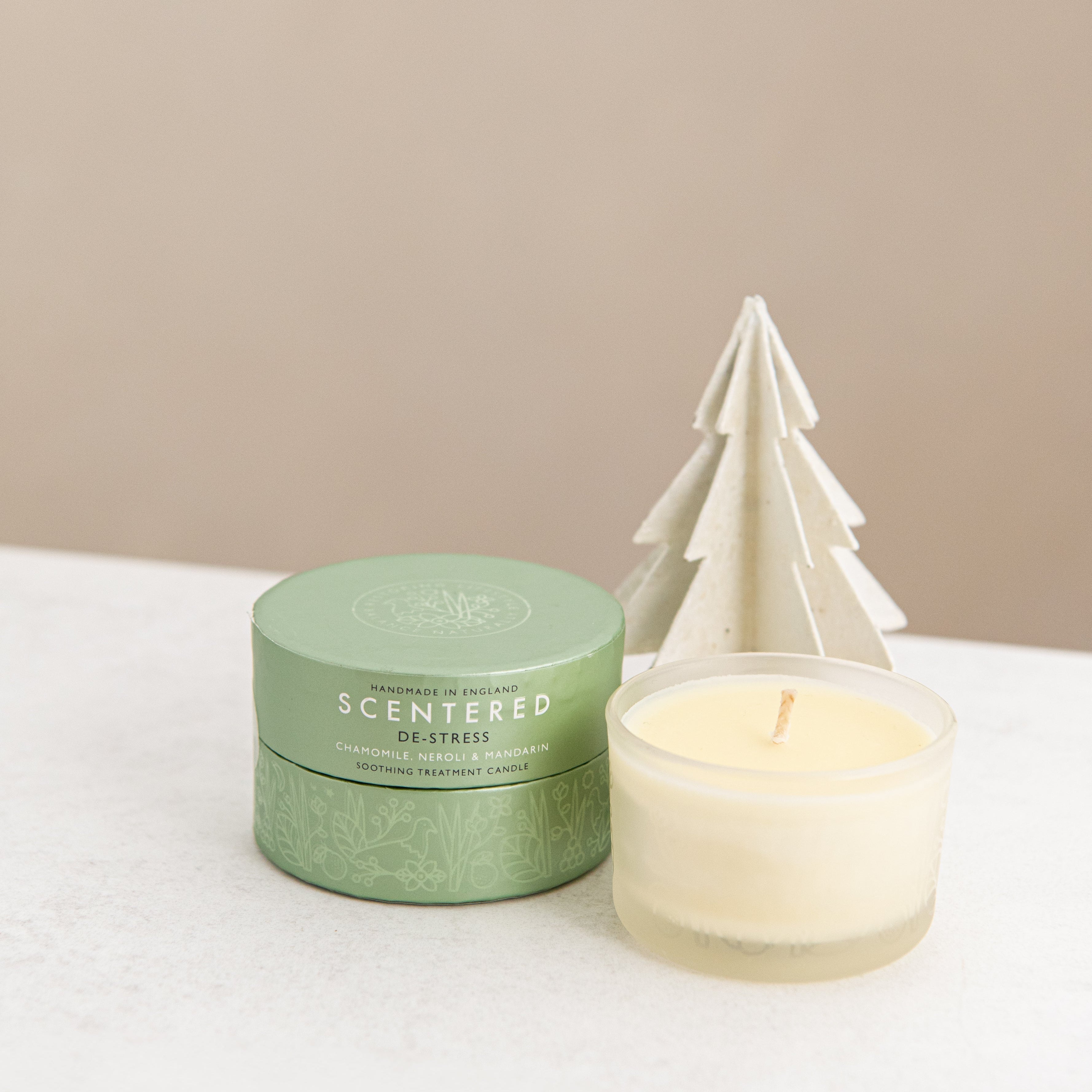 De-stress candle and package with Christmas tree decoration.