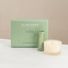 Scentered product packaging with a de-stress balm and candle on a white surface.