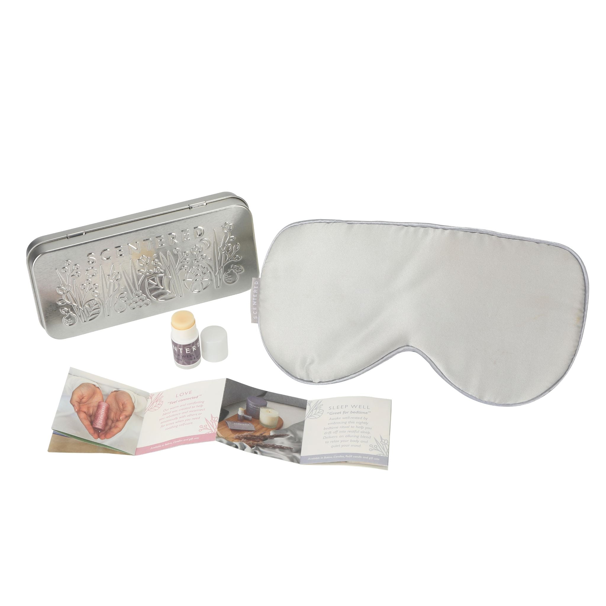 Silk eye mask, travel tin, Sleep Well mini balm and pamphlet on a white background