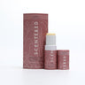 Love Aromatherapy Balm with cap off and twisted up with eco sleeve packaging on a white background