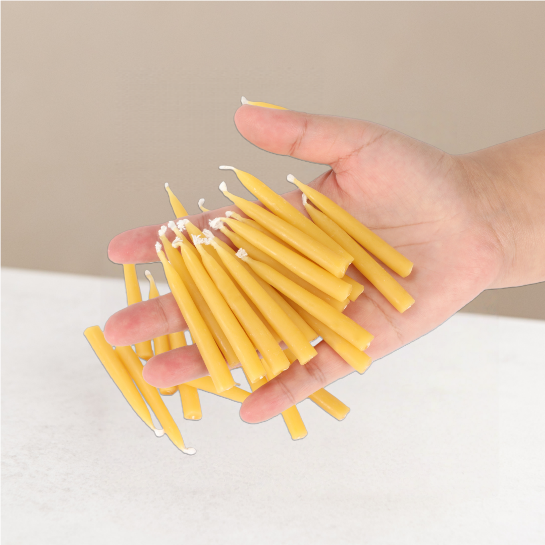 Hand holding a bundle of yellow candles against a warming background