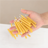 Hand holding a bundle of yellow candles against a warming background