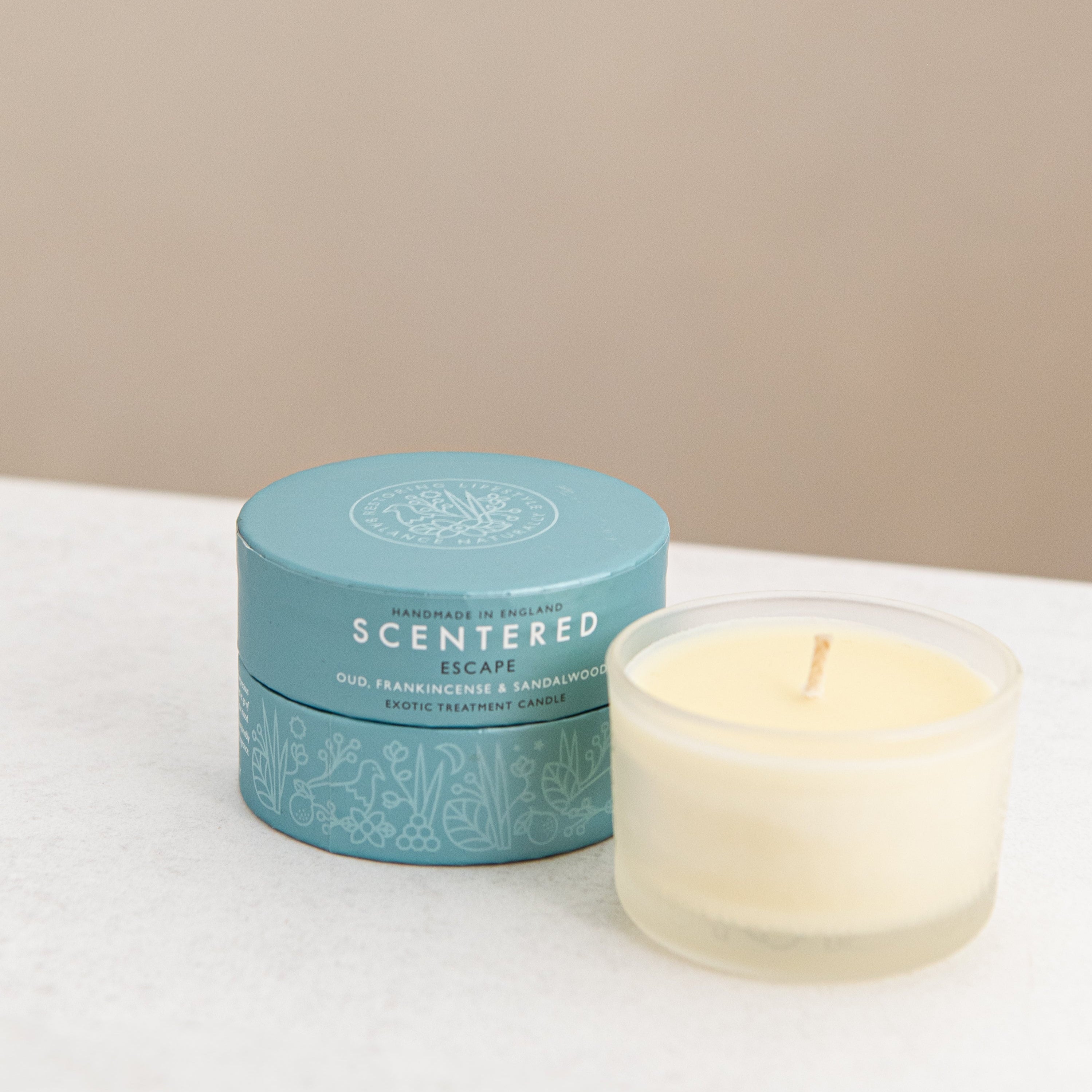 Scented candle with blue gift box  on a desk.