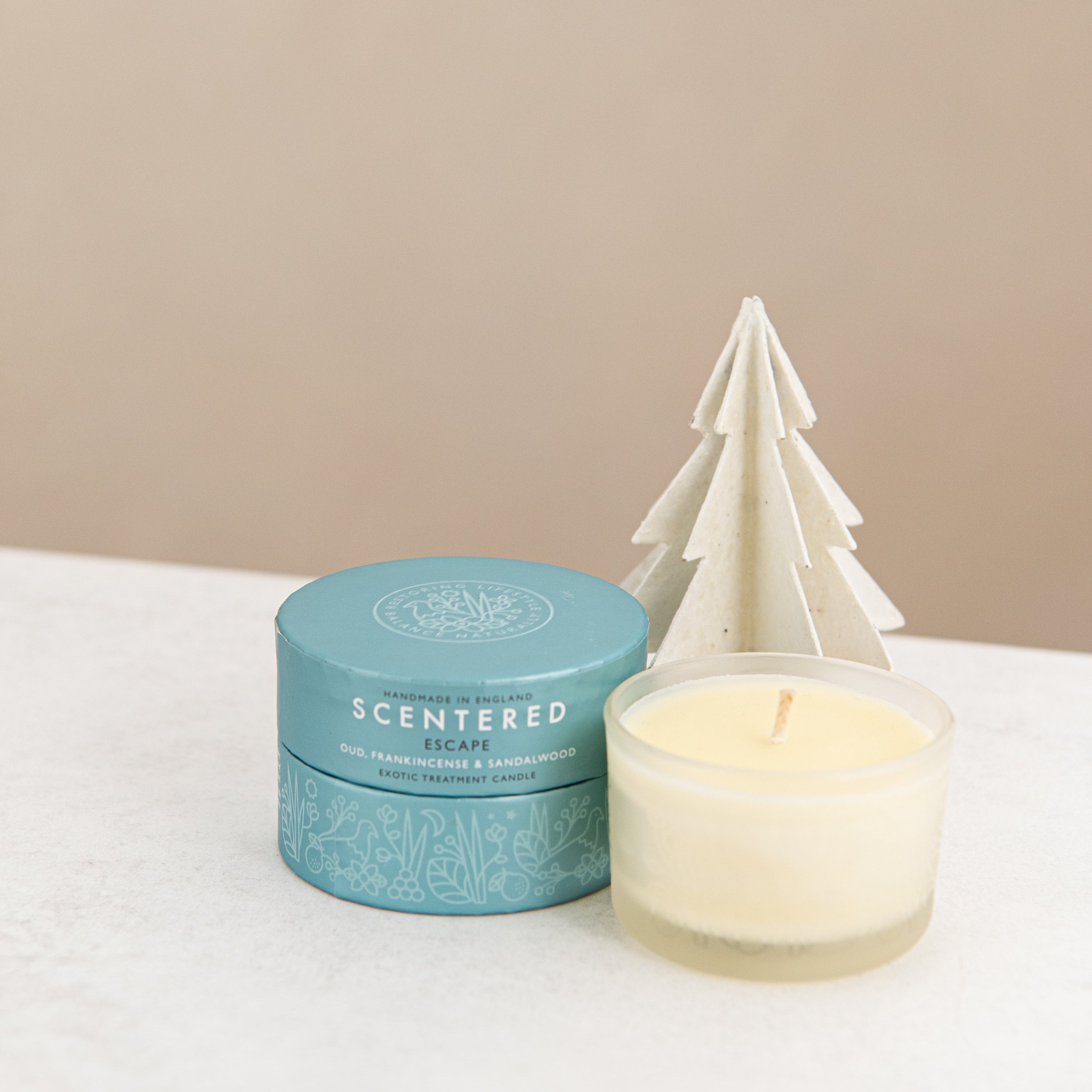 Escape candle and package with Christmas tree decoration.