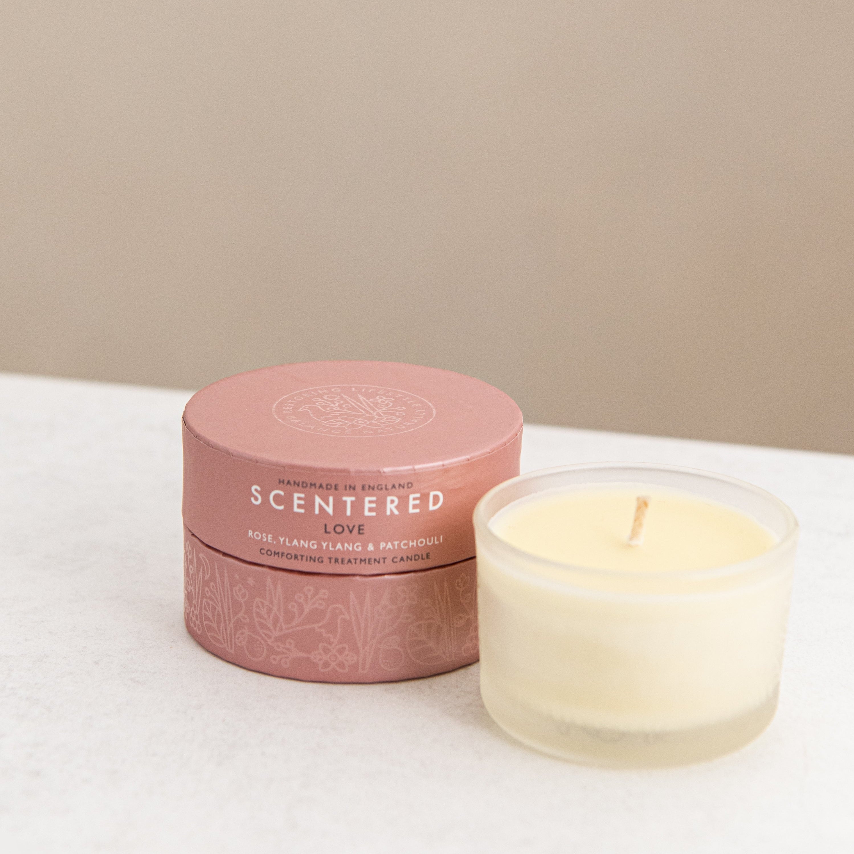 A love candle with pink gift box on the desk.