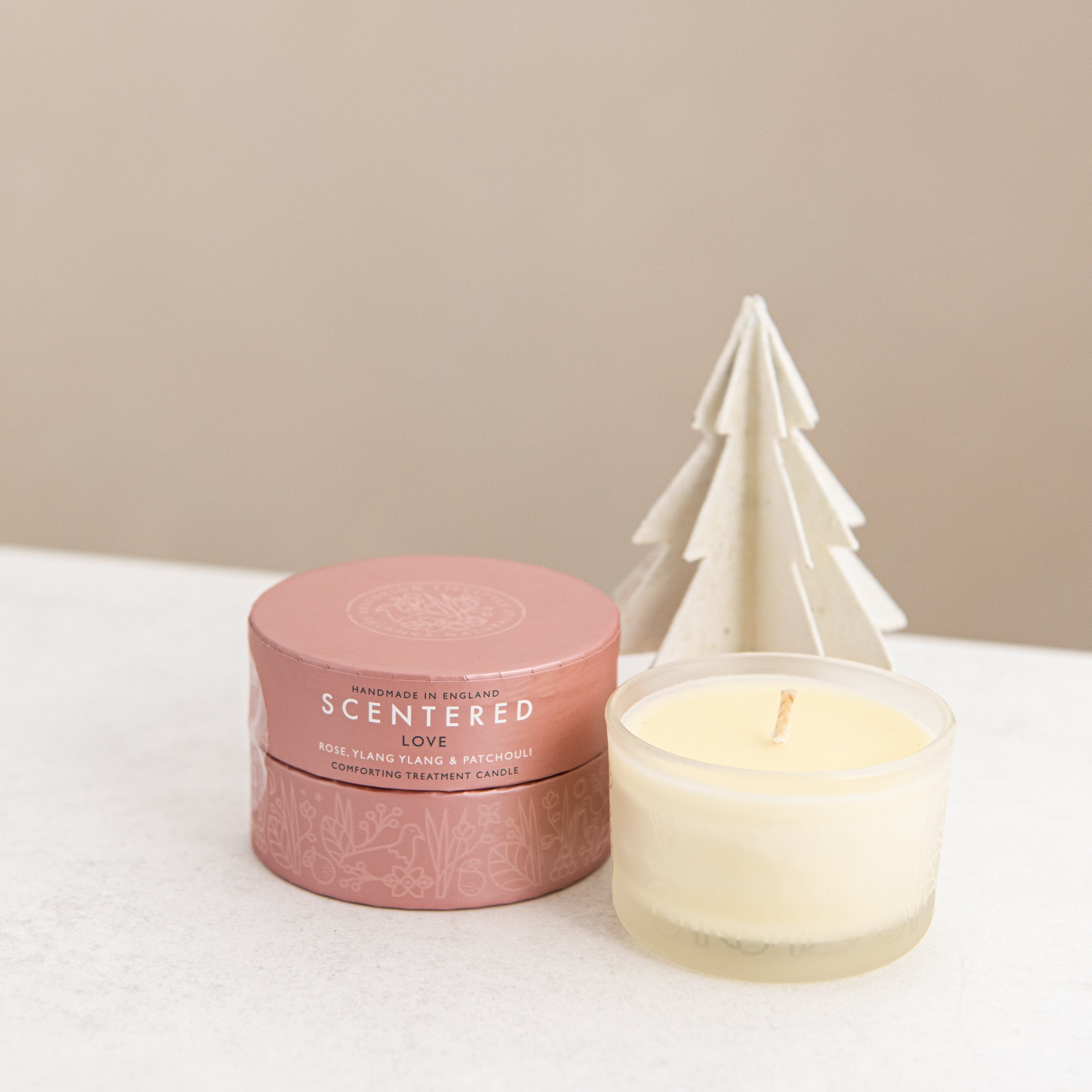 Love candle and package with Christmas tree decoration.