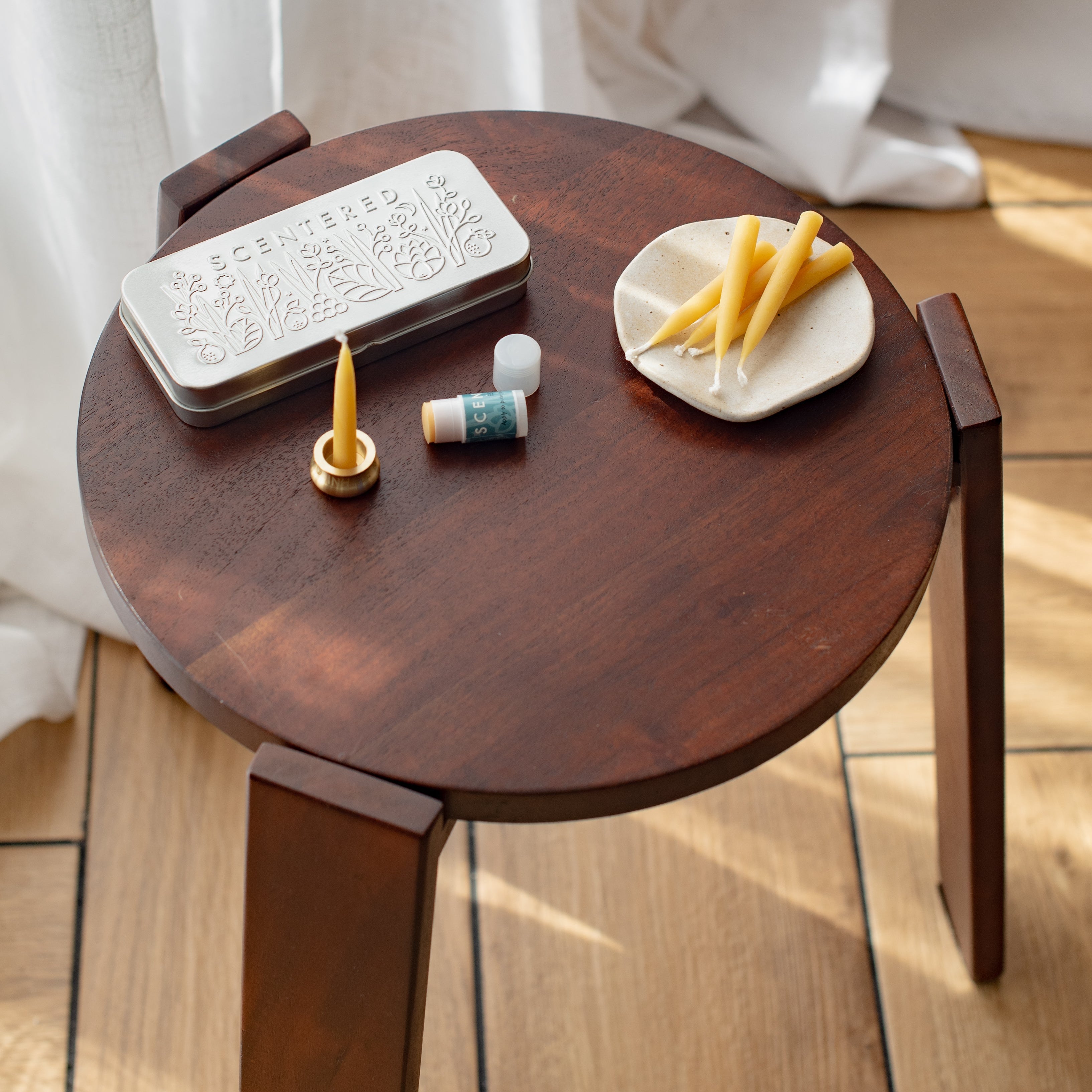 Small wooden table with mindful escape balm set including a mini escape balm and a lot of yellow bee wax.