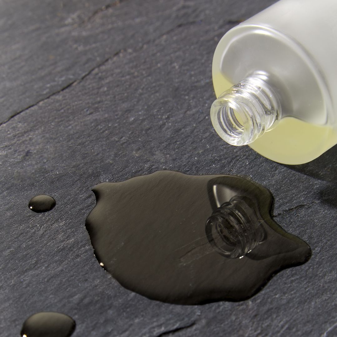 Scentered Sleep Well Body oil on a black slate from tipped over bottle 
