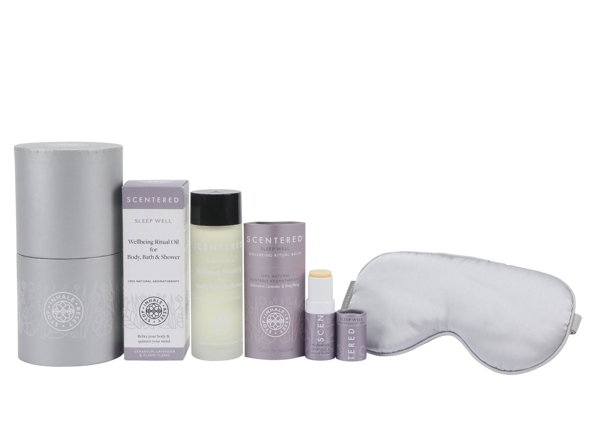 Sleep wellness products including a Sleep Well Aromatherapy Balm, eye mask, and Sleep Well body oil on a white background.