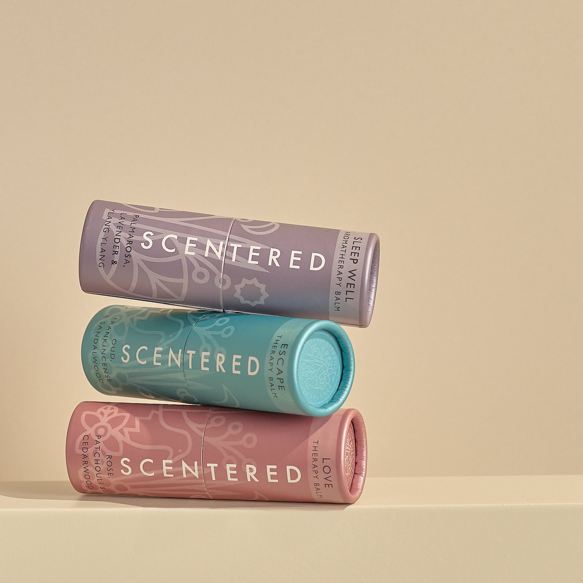 Three balms stacked on a beige background