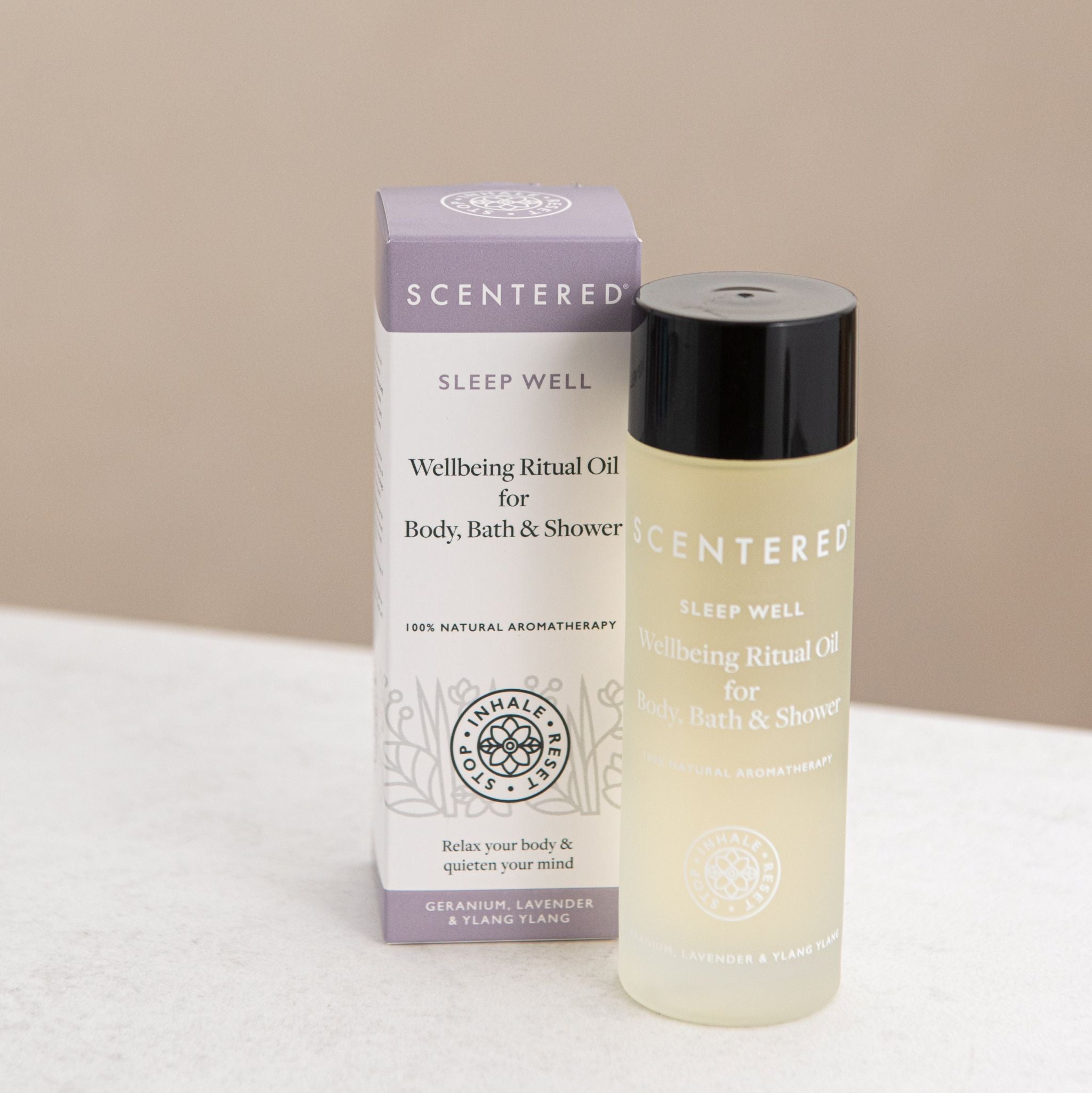 Scentered Sleep Well Body oil in bottle next to it's box on a beige background