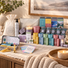The wellbeing booster box includes a white drawstring bag, a De-stress Body Wash pump bottle, 2 large candles, 4 gift tins ins, 6 pulse point aromatherapy balms, felt stockings, silver gift bag, a refill balm dup and other small home-care items.