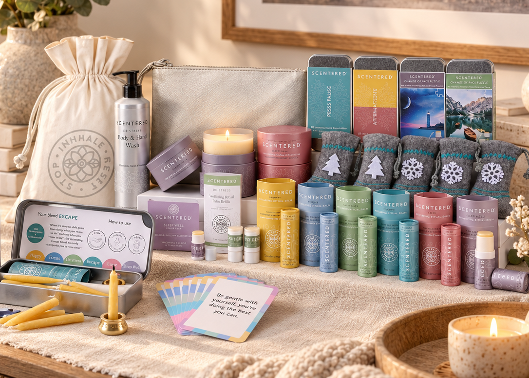 The wellbeing booster box includes a white drawstring bag, a De-stress Body Wash pump bottle, 2 large candles, 4 gift tins ins, 6 pulse point aromatherapy balms, felt stockings, silver gift bag, a refill balm dup and other small home-care items.