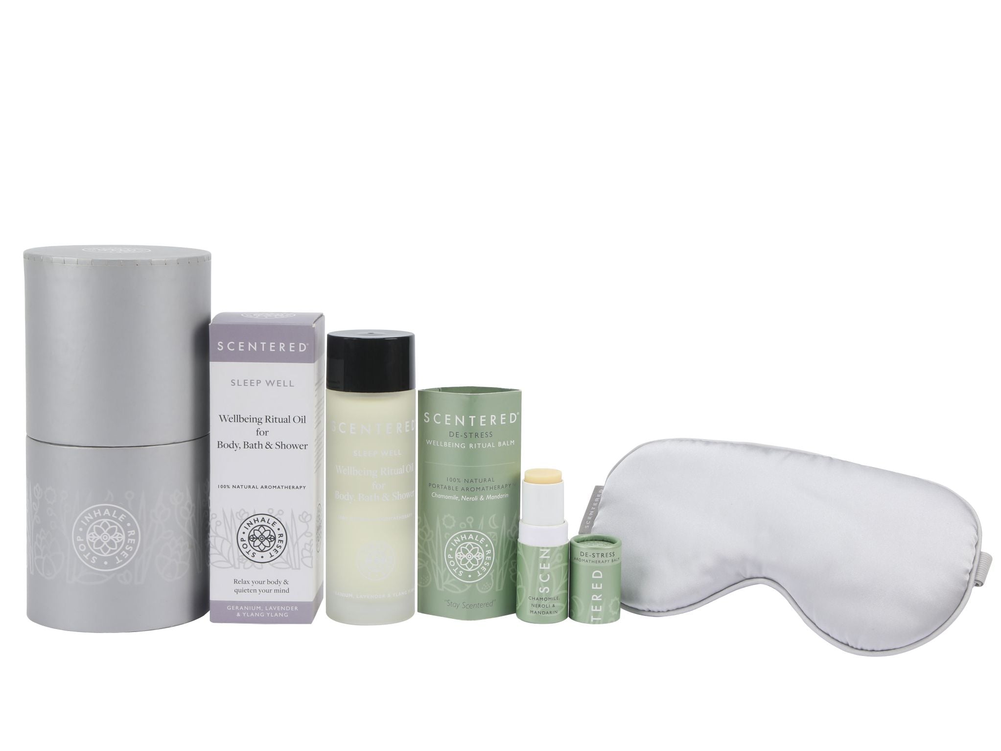 Wellness products including a De-stress Aromatherapy Balm, eye mask, and Sleep Well body oil on a white background.