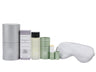Wellness products including a De-stress Aromatherapy Balm, eye mask, and Sleep Well body oil on a white background.