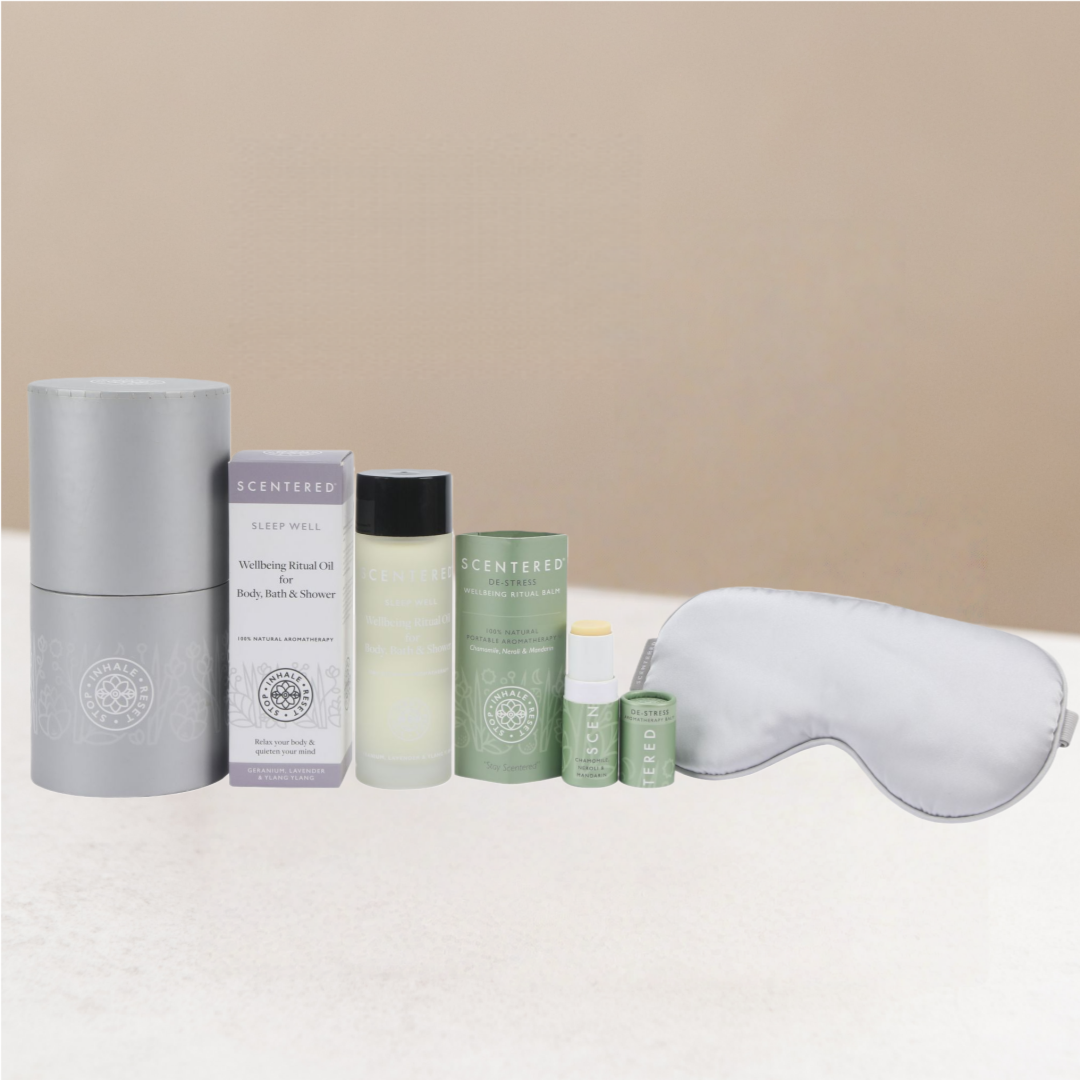 Collection of sleep care products including eye mask, de-stress balm, body oil and box on a warming background.