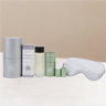 Collection of sleep care products including eye mask, de-stress balm, body oil and box on a warming background.