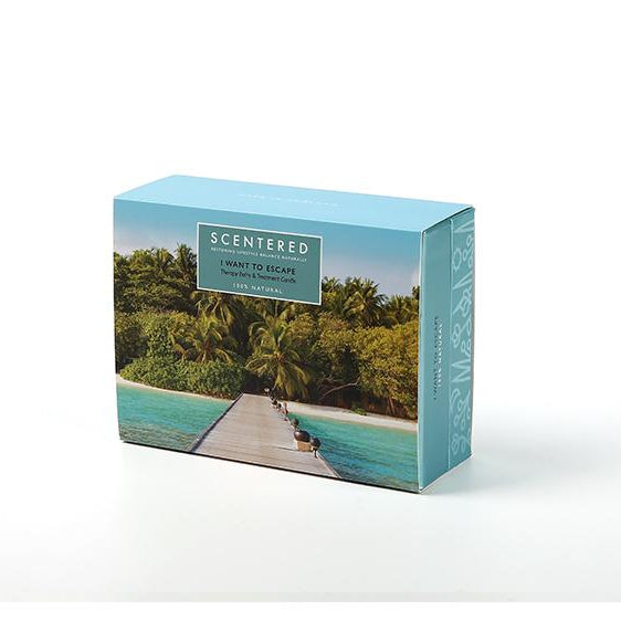 Scentered Escape aromatherapy gift set box with a tropical design showing a boardwalk leading to lush palm trees and turquoise water, evoking a sense of relaxation and adventure.